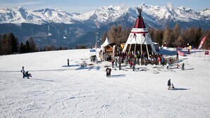 A snow-covered ski slope with a large gathering of people and a prominent red and white tent structure. - Luxury Studio 4 Pers (Veysonnaz)