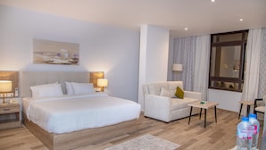 A hotel room with a large bed, a sofa, a small table, and a window with curtains. - AL Farida Boutique Pyramids (Giza)