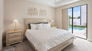A bedroom with a bed, two bedside tables, a ceiling fan, and a view of a swimming pool. - Dolce Far Niente - Villa Domani (Davenport)