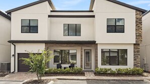 A modern two-story house with a garage, large windows, and a small garden area. - Dolce Far Niente - Villa Domani (Davenport)