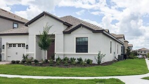 A single-story residential house with a white exterior, a brown roof, and a front garage.
