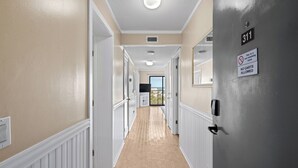 A hallway with a beige wall, white trim, and a grey door marked with '311' and 'NO Carts Allowed'. - A311 at the Myrtle Beach Resort (Myrtle Beach)
