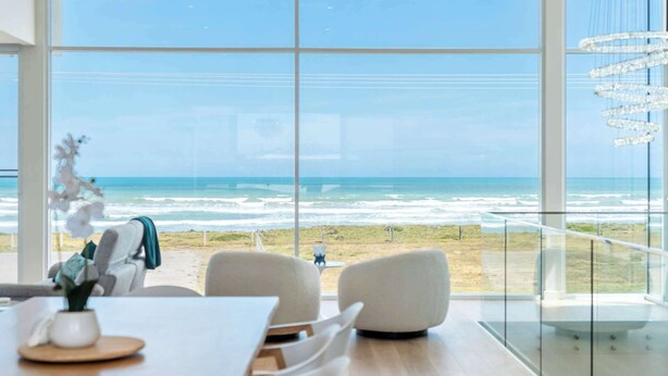 A modern interior with large windows offering a view of the ocean. - Casa Bianca 50 Esplanade Middleton (Middleton)