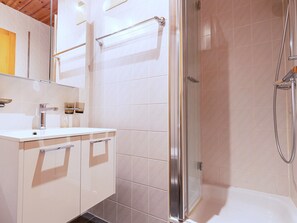 A modern bathroom with a glass shower enclosure, a white sink, and a mirror. - Stunning Apartment With Mountain Views (Veysonnaz)