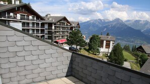 A hotel with a terrace overlooking mountains. - Stunning Apartment With Mountain Views (Veysonnaz)