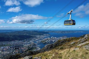 A cable car system over a town with a lake and mountains in the background. - Apartment in the city center - balcony (Bergen)
