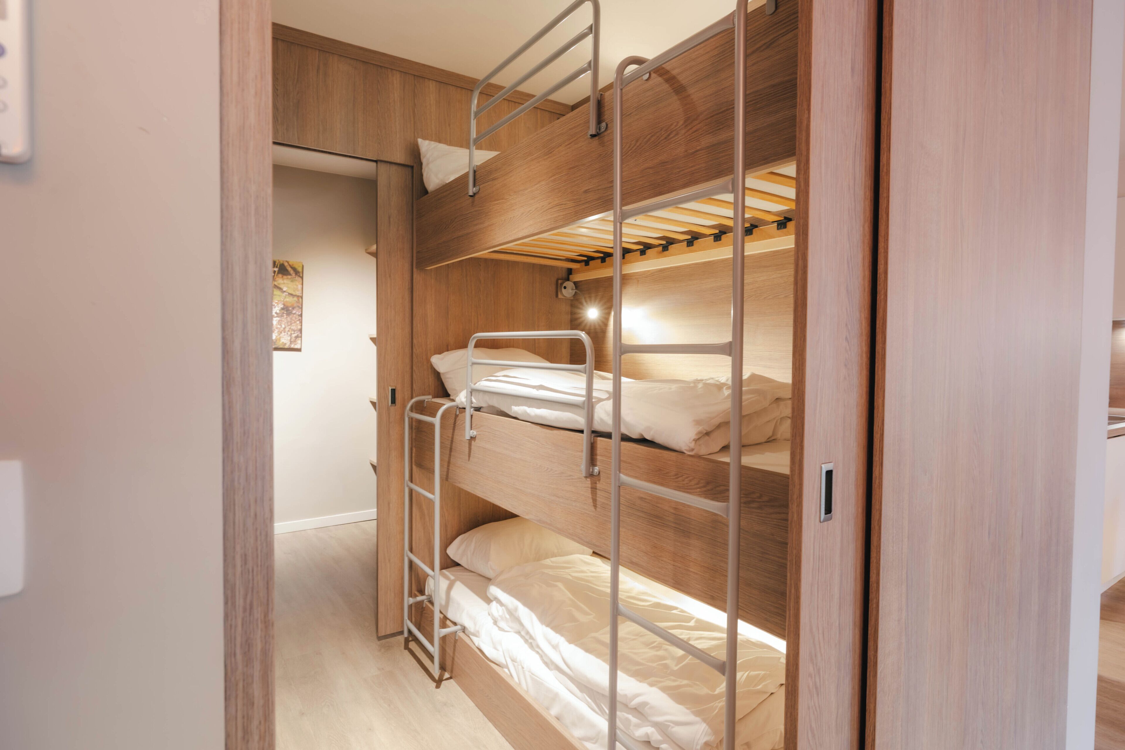 A bunk bed room with wooden walls and a ladder.