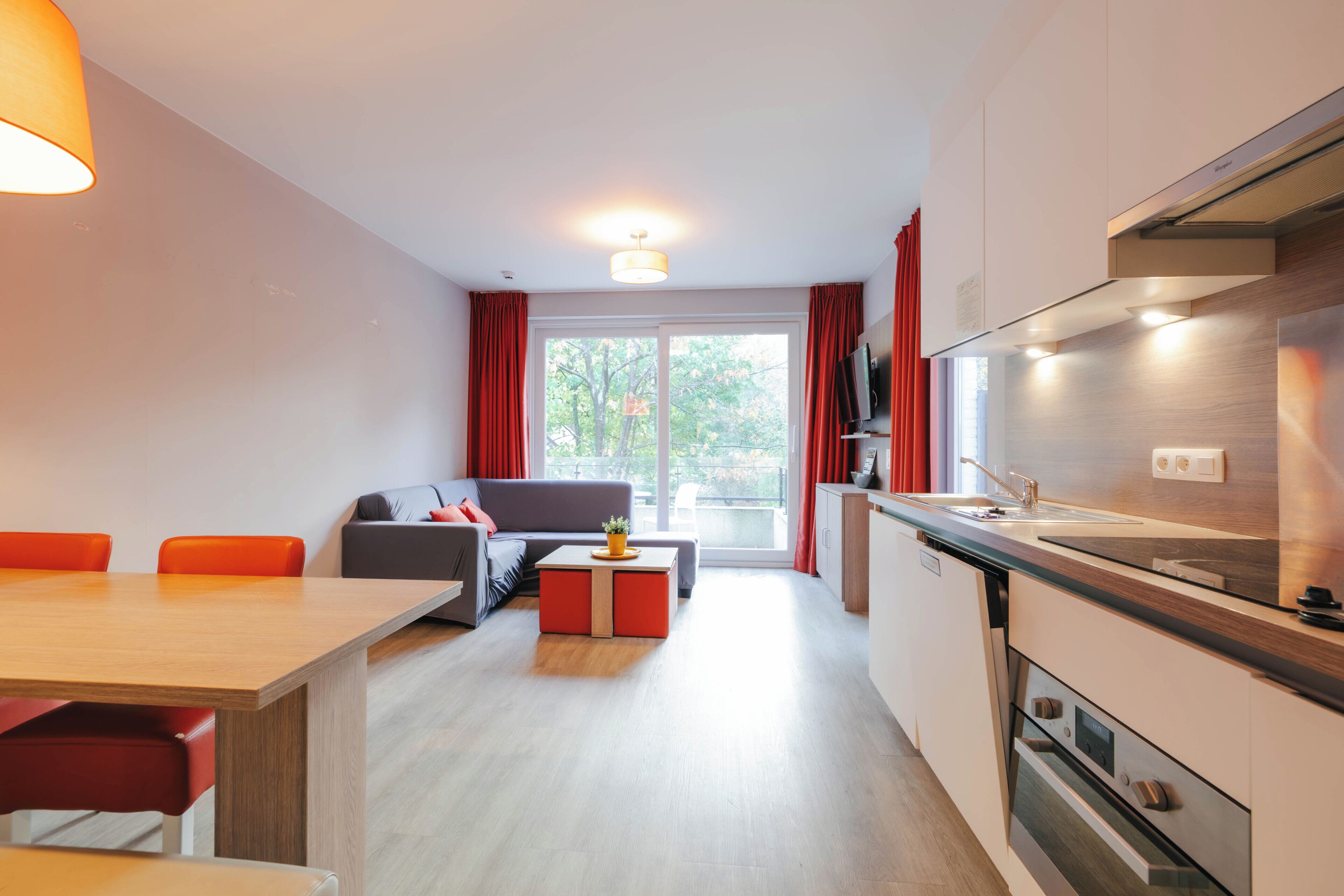 Una cocina moderna con comedor, sofá y vistas al exterior.