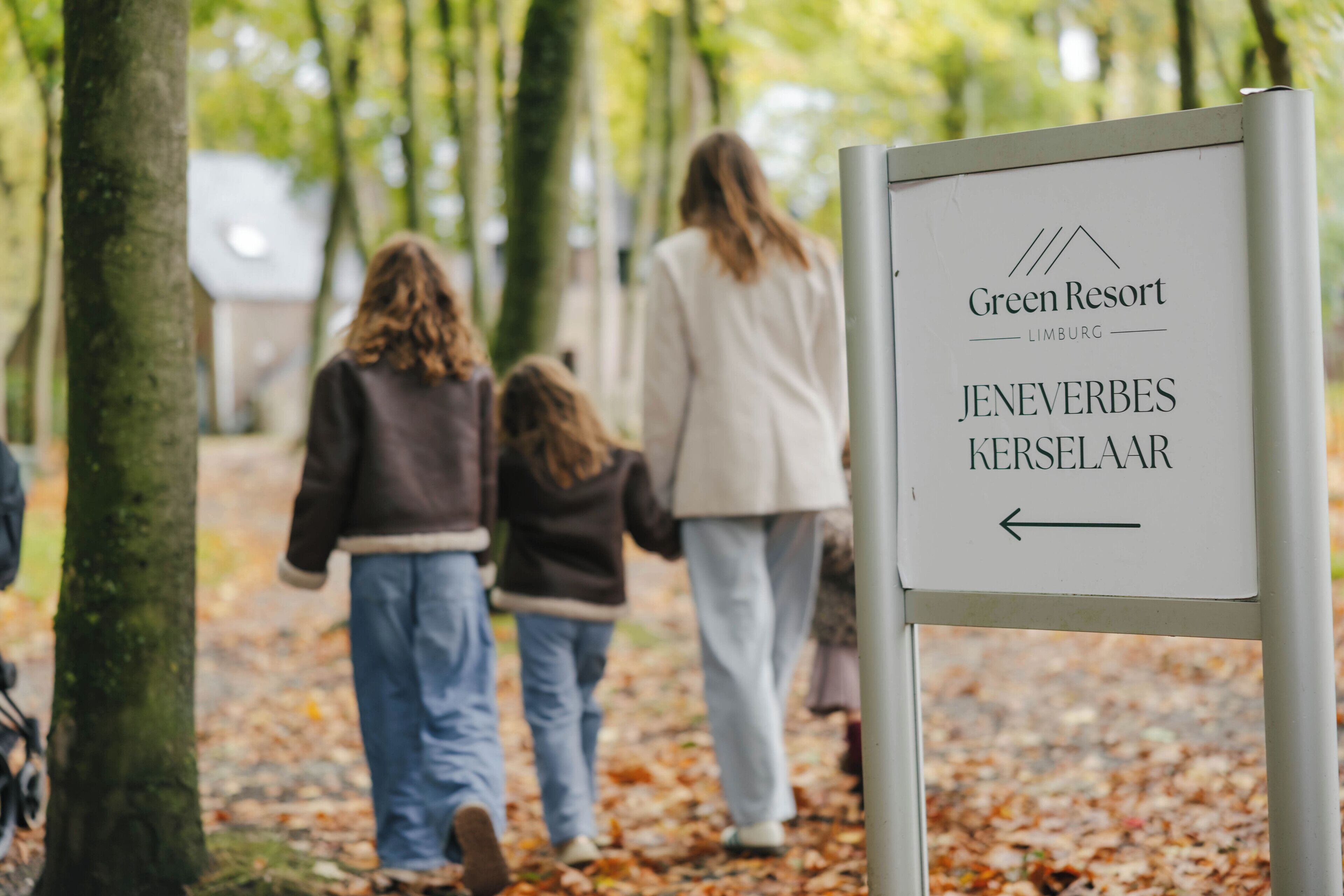 A sign for Green Resort in Jenevers Kerselaar with an arrow pointing left.