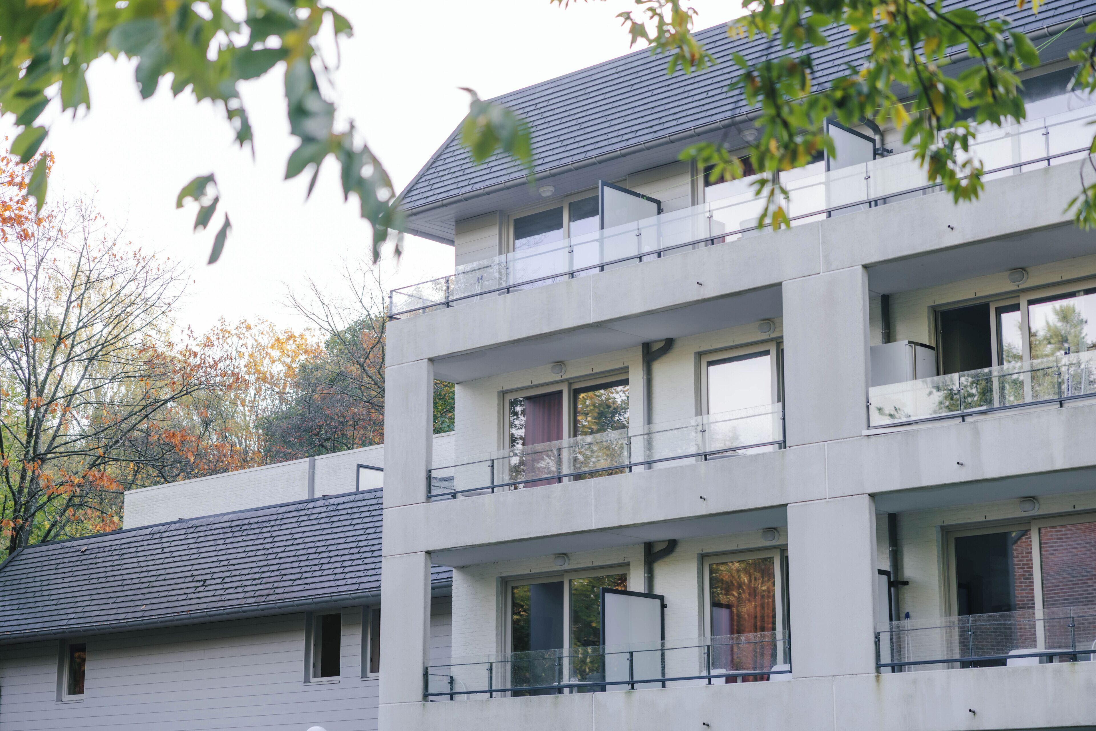 A multi-story building with balconies and large windows.