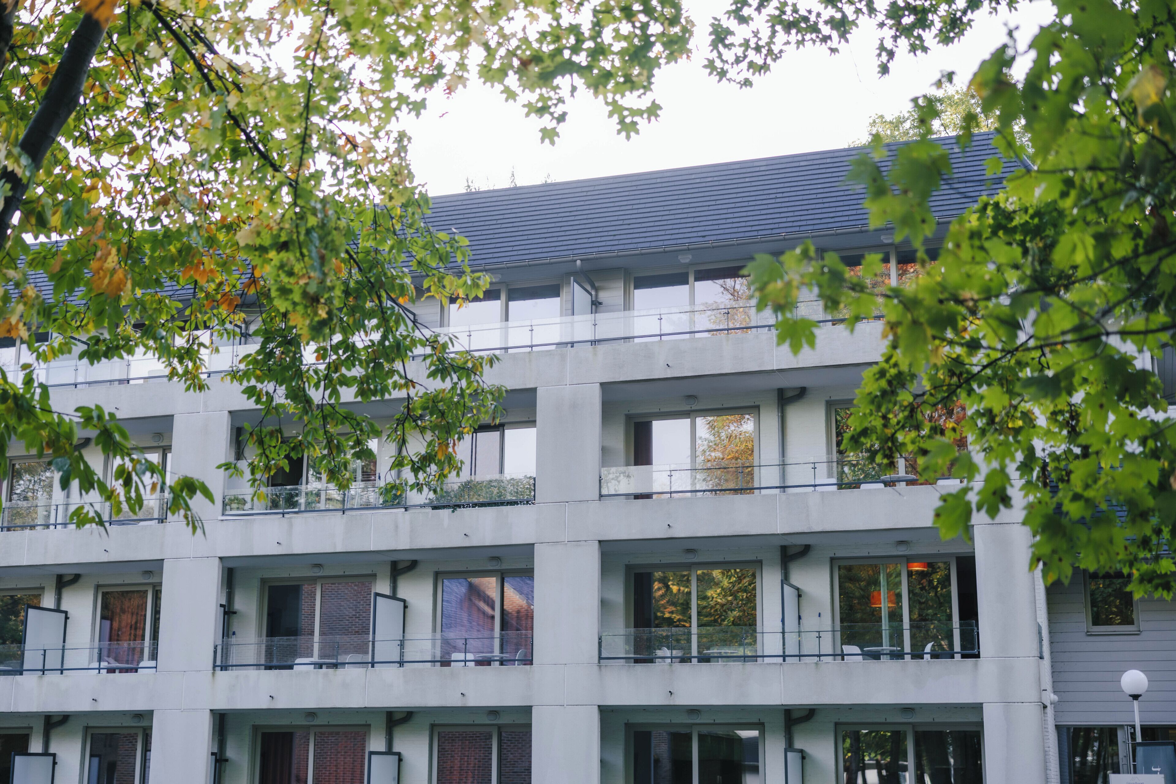 A multi-story building with balconies and large windows.