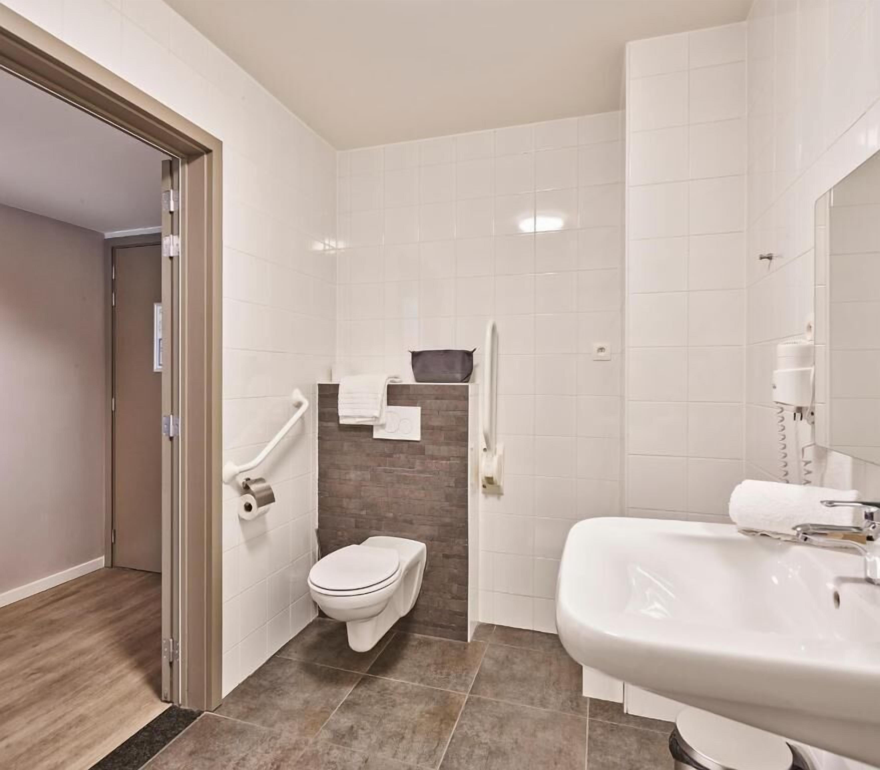 Un baño moderno con inodoro, lavabo y ducha.