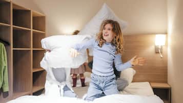 Una habitación de hotel con una cama, un armario de madera y una mesita de noche con lámpara.