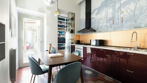 A modern kitchen with dark cabinets, a central island, and pendant lighting. - Colosseo book house (Rome)