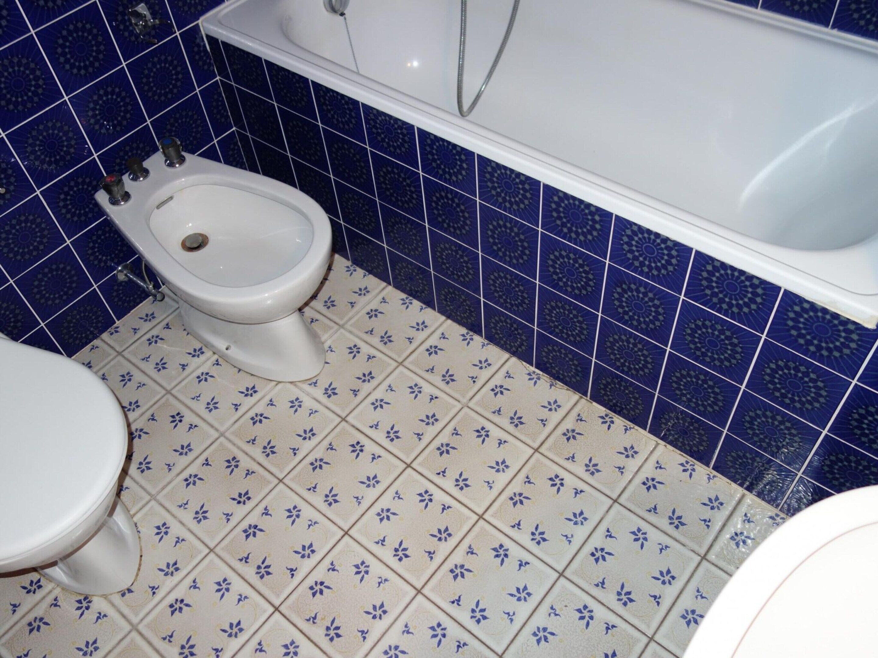 Un baño con inodoro, bidé y bañera.