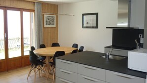 Una cocina moderna con comedor, piso de madera y un ventanal con vistas.