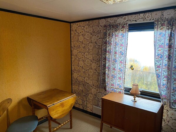 A room with a wooden desk, a chair, and a window with patterned curtains. - 8 Person Holiday Home in Svensby (Lyngen)
