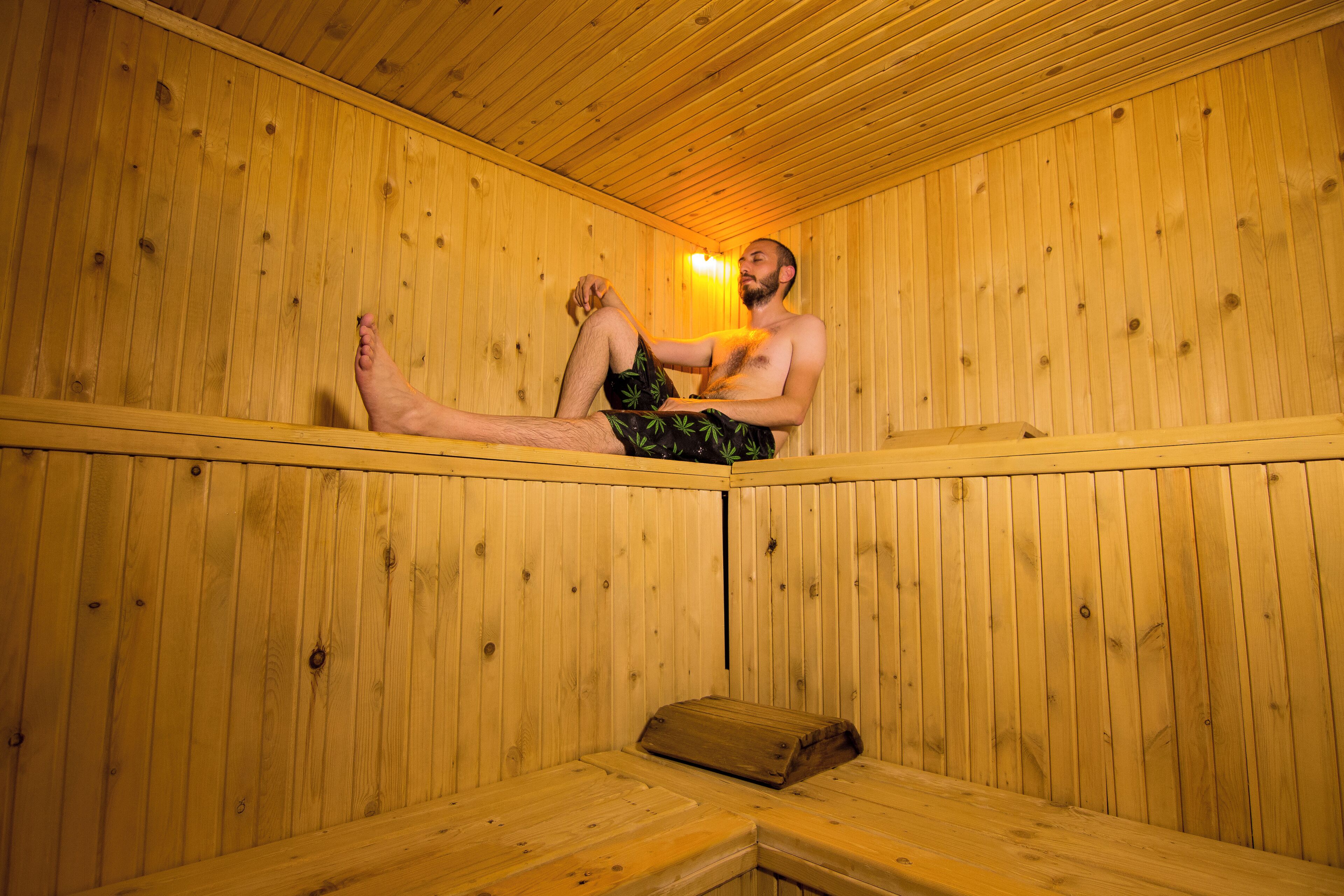 A wooden sauna with a bench and a bench cover.