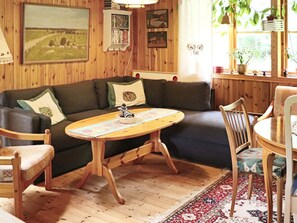 A cozy living room with a wooden floor, a sofa, a round wooden coffee table, and a patterned rug. - 4 Star Holiday Home in Kalv (Kalv)