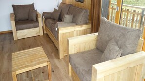 Ein gemütliches Zimmer mit drei hölzernen Sofas und einem kleinen Holztisch.