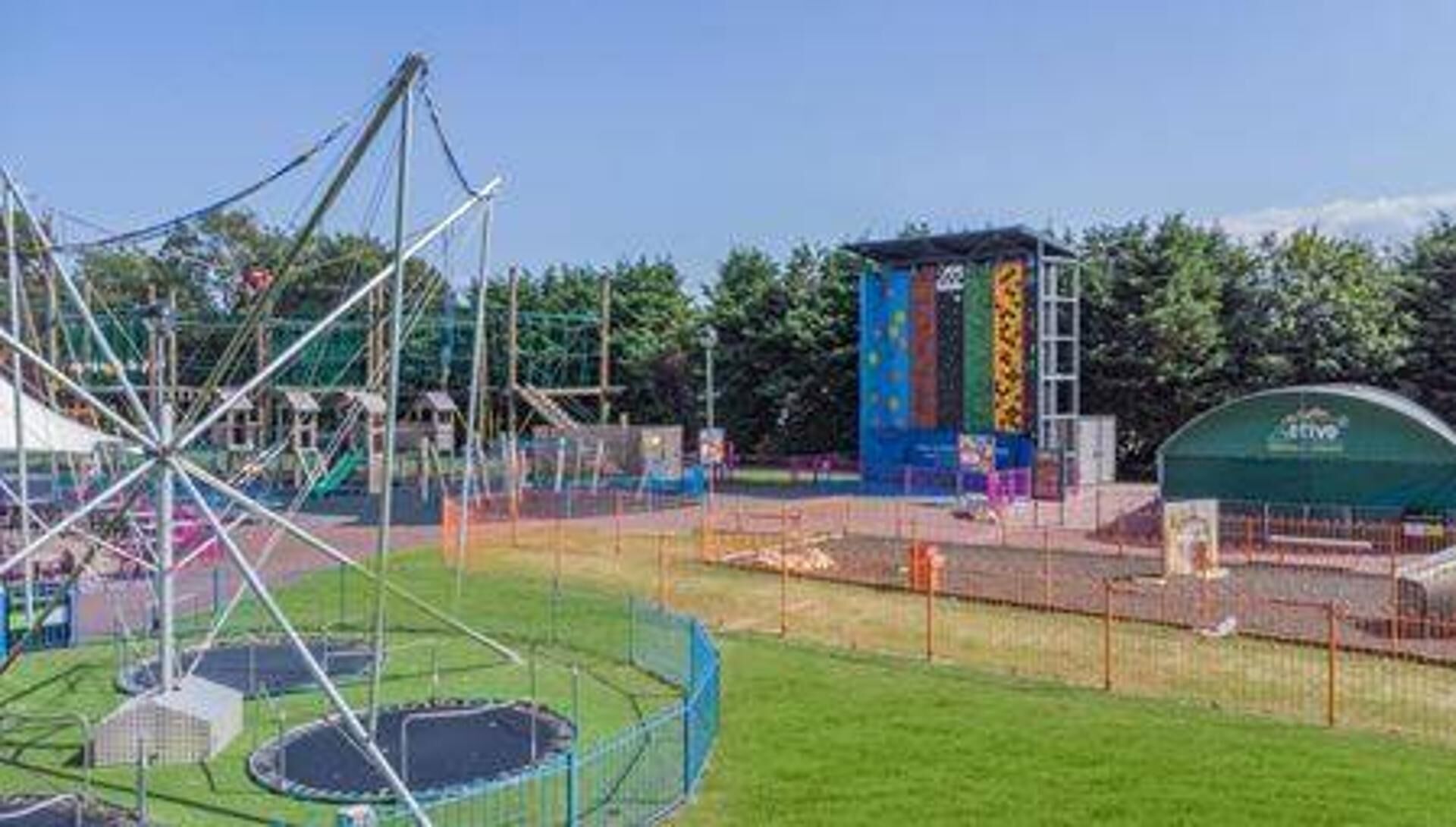 A playground with a swing set and a fenced area.