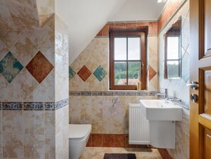 Un baño con inodoro, lavamanos y ventana.