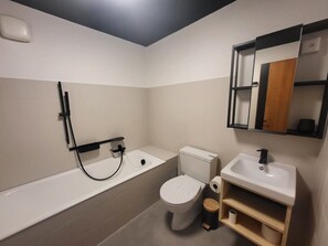 Une salle de bain moderne avec une baignoire, des toilettes et un lavabo.