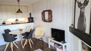Un salon moderne comprenant un coin repas, un téléviseur et une cheminée.