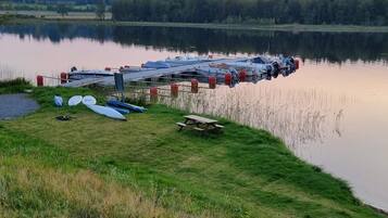 A lakeside dock with boats and a picnic table.