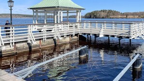 Eine hölzerne Pier mit einem Pavillon, die sich in ruhiges Gewässer erstreckt.