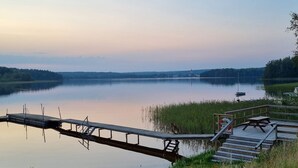Ein ruhiger See mit einer hölzernen Mole und Picknicktischen.