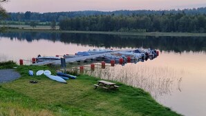 Un quai avec des bateaux et une table de pique-nique au bord d’un lac paisible.