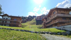 A mountain village with wooden buildings, a clear sky, and a sunny day. - Spacious Apartment for ski Holiday (Veysonnaz)