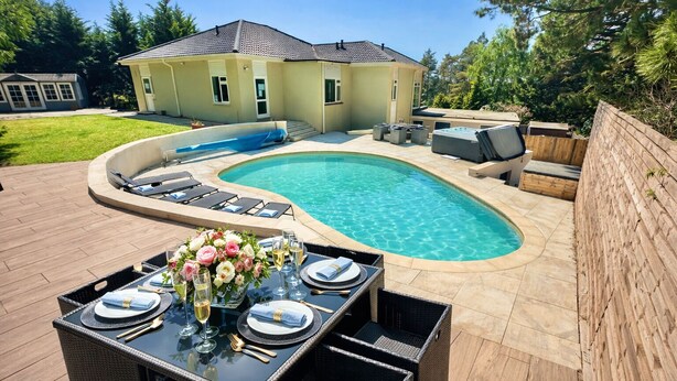 Un patio trasero con piscina, mobiliario exterior y zona de comedor.