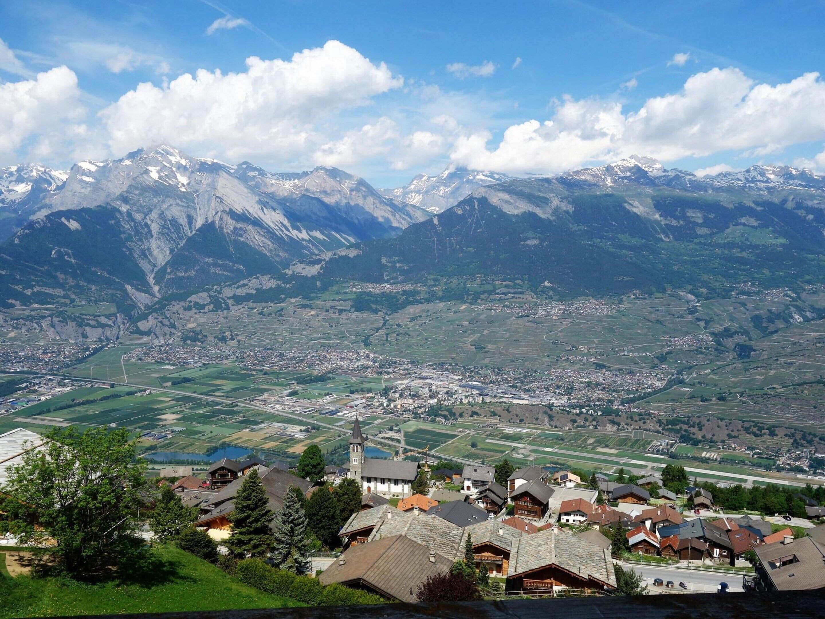 A mountainous landscape with a village nestled in the valley.