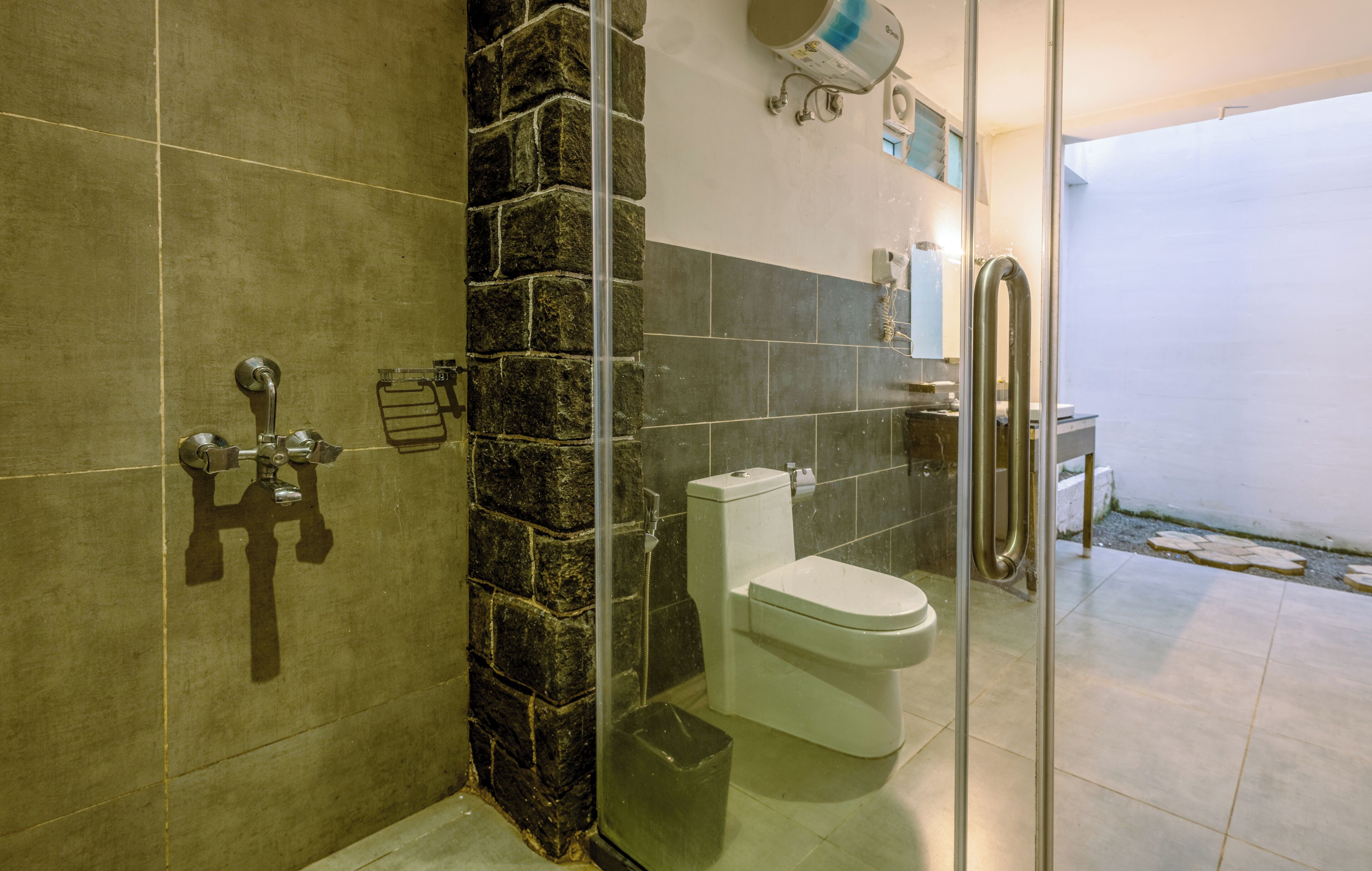 Un baño con ducha, inodoro y puerta de cristal.
