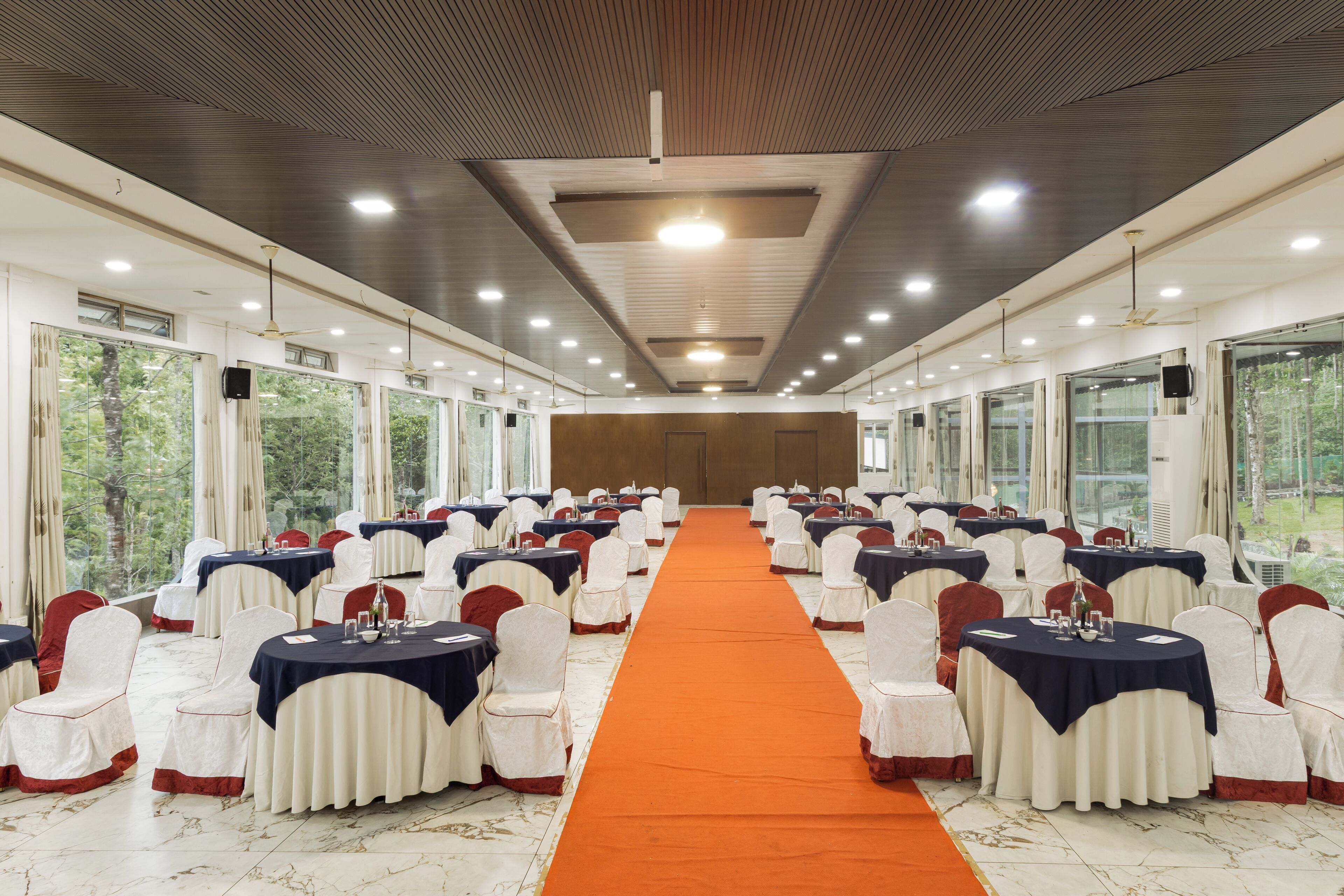 A conference room with a long table, chairs, and a carpeted aisle.