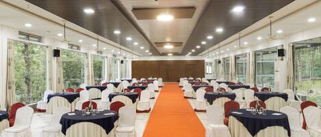 A conference room with a long table, chairs, and a carpeted aisle.