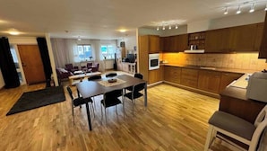 Eine moderne Küche mit Holzschränken und einem Essbereich mit Tisch und Stühlen.