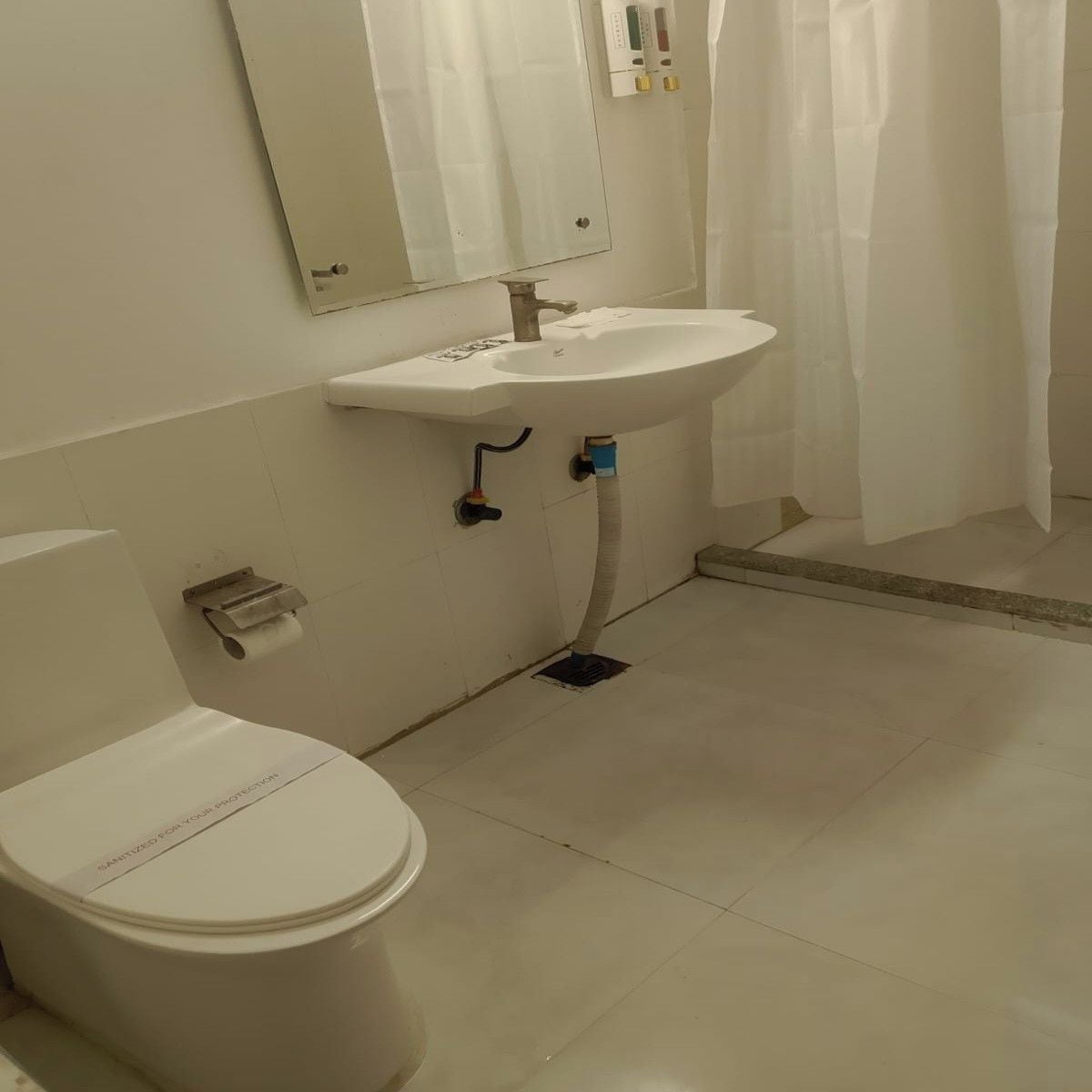 Un bagno con il water, lavandino e tenda della doccia.