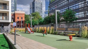 Un parque infantil con un tobogán, una bicicleta pequeña y un hidrante.