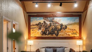 Un accogliente soggiorno con un grande quadro, divani in pelle, un tavolino da caffè e un tappeto.