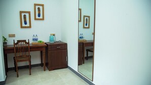 A room with a wooden desk, a chair, a cabinet, a mirror, and a potted plant. - Aaradhya Madu River  (Ambalangoda)