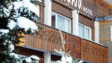 Un hotel con fachada de madera y un balcón con diseños elaborados.