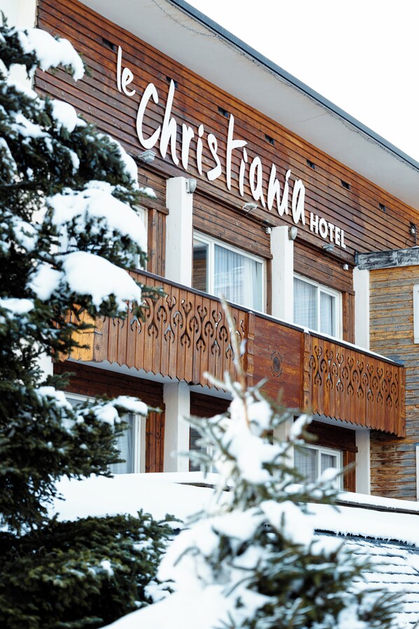 A hotel with a wooden facade and a balcony with intricate designs. - Hôtel Le Christiania Saint Lary Soulan (Saint-Lary-Soulan)