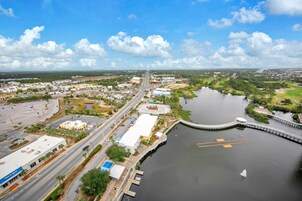 An aerial view of a coastal city with a marina, roads, and buildings.