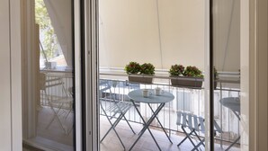 Uma varanda com mesa, cadeiras e plantas em vasos.