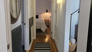 A hallway leading to a bedroom with a bed, a bedside lamp, and a nightstand. - MARGARET'S PLACE ON SUNNYSIDE. A charming home for countryside relaxation (Greeneville)