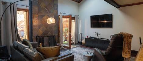 Una Smart TV, una chimenea, libros, una pantalla de ordenador