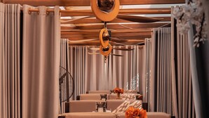 A restaurant with a long dining area, wooden ceiling, and curtains. - Tchetche Hotel & Restaurant (Accra)